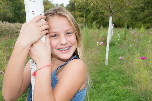 Photo pretty blond girl closeup portrait against green grass