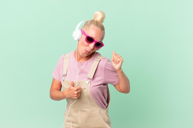 Pretty blond woman listening music with a headphones