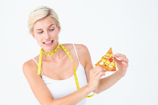 Довольно блондинка, выбирающая между едой пиццы или нет