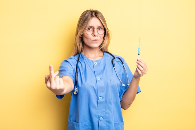 Photo pretty blonde girl feeling angry, annoyed, rebellious and aggressive. nurse an vaccine concept