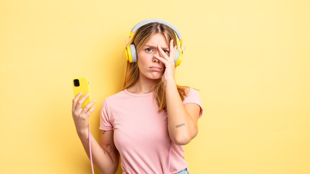 Photo pretty blonde girl feeling bored, frustrated and sleepy after a tiresome. listening music concept