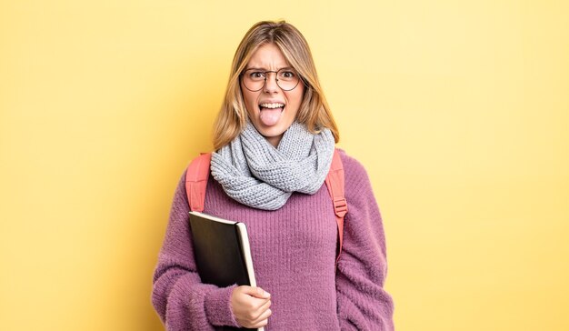 Pretty blonde girl feeling disgusted and irritated and tongue out. student concept