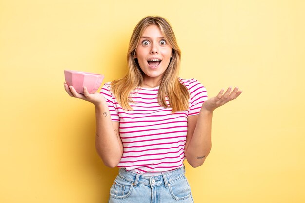 Pretty blonde girl feeling happy and astonished at something unbelievable. empty bowl concept