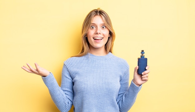 Pretty blonde girl feeling happy, surprised realizing a solution or idea. smoke vaporizer concept