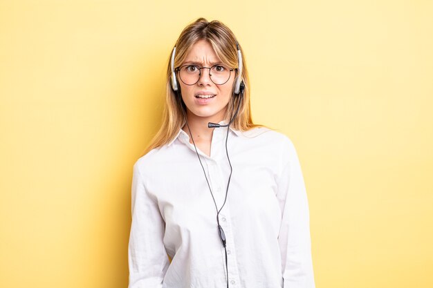 Pretty blonde girl feeling puzzled and confused. headset concept