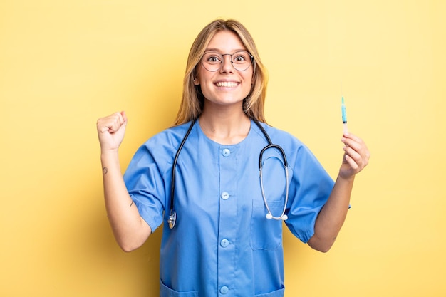 Pretty blonde girl feeling shocked,laughing and celebrating success. nurse an vaccine concept