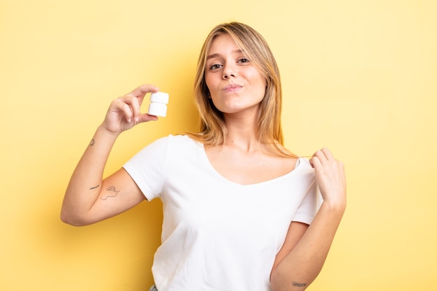 Pretty blonde girl looking arrogant, successful, positive and proud. pills bottle concept