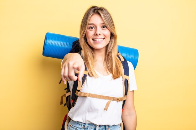 Pretty blonde girl pointing at camera choosing you.  hiker concept