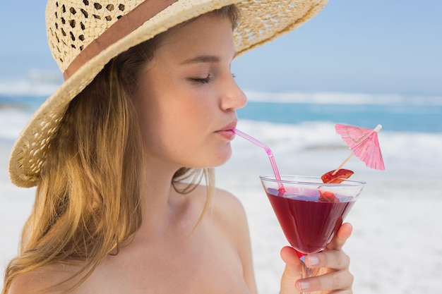 Pretty blonde sipping cocktail on the beach