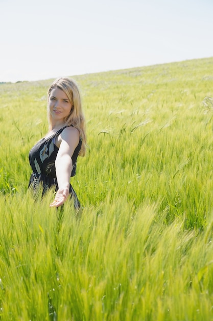 Pretty blonde in sundress standing in wheat field