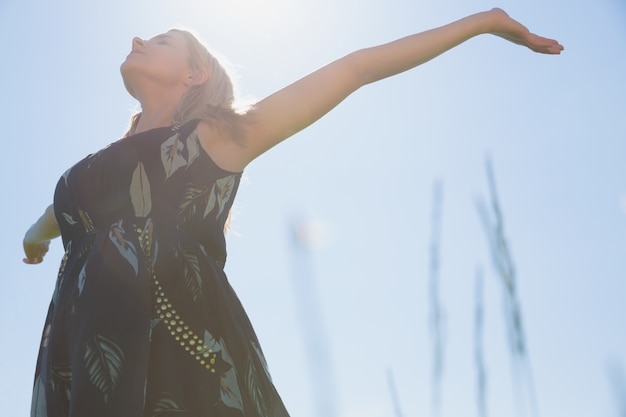 Photo pretty blonde in sundress standing with arms out