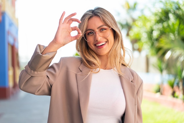 Foto bella donna uruguaiana bionda con gli occhiali e facendo segno ok