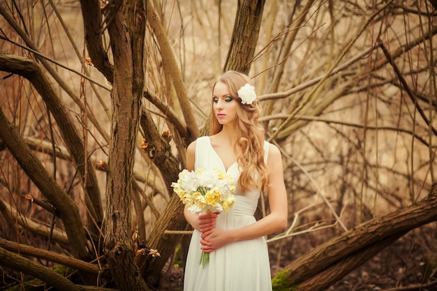 Pretty blonde with a bouquet of flowers is spring Park