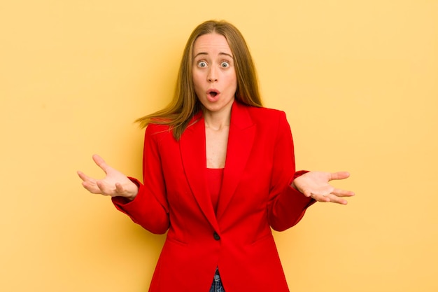 Pretty blonde woman feeling extremely shocked and surprised businesswoman concept