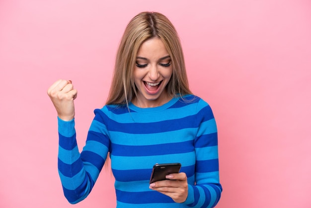 Pretty blonde woman isolated on pink background surprised and sending a message