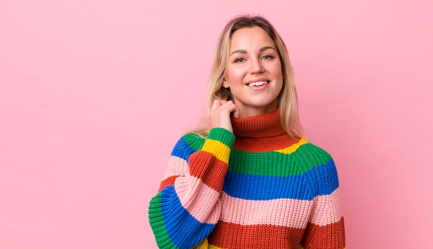 Pretty blonde woman laughing cheerfully and confidently with a casual happy friendly smile