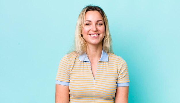 Pretty blonde woman looking happy and goofy with a broad fun loony smile and eyes wide open