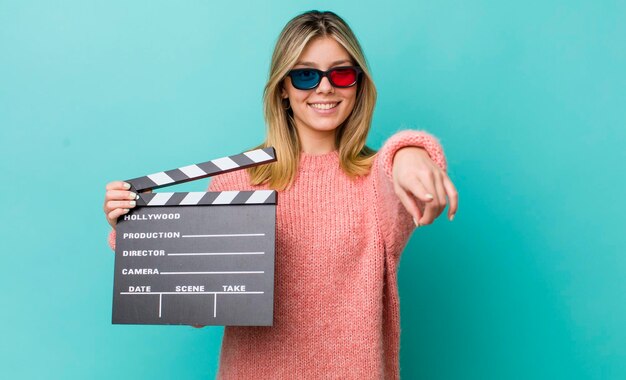 Pretty blonde woman pointing at camera choosing you cinema concept