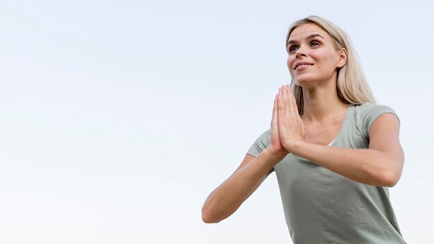 Foto bella bionda donna a praticare yoga in spiaggia