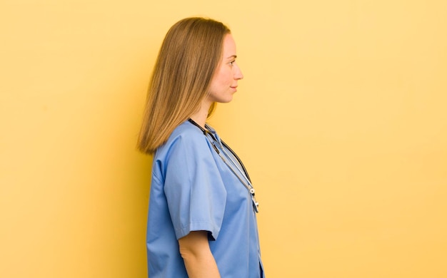 Pretty blonde woman on profile view thinking imagining or daydreaming nurse concept