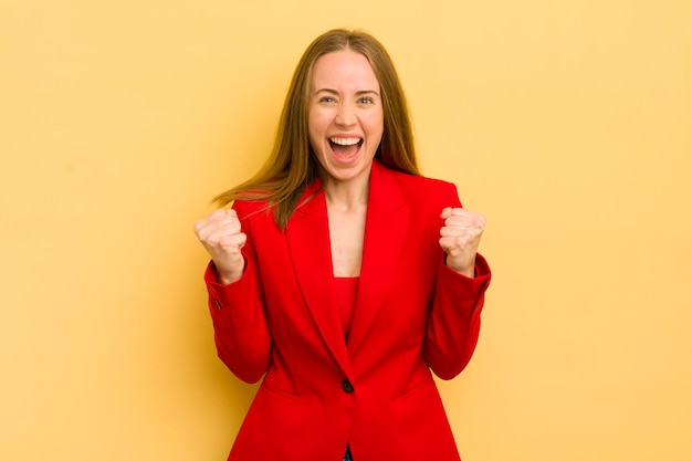 Pretty blonde woman shouting aggressively with an angry expression businesswoman concept