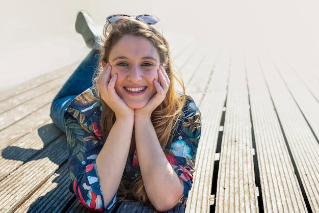 Pretty blonde woman smiling at the camera in the park - stock photo