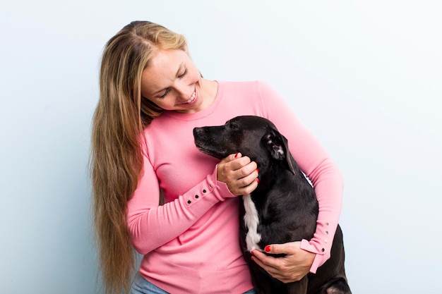 彼女の犬と一緒に楽しんでいるかなり金髪の若い大人の女性