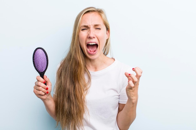 Pretty blonde young adult woman with a hair comb