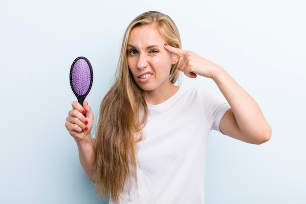 Pretty blonde young adult woman with a hair comb