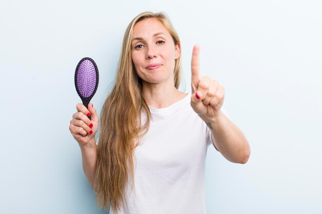 Pretty blonde young adult woman with a hair comb