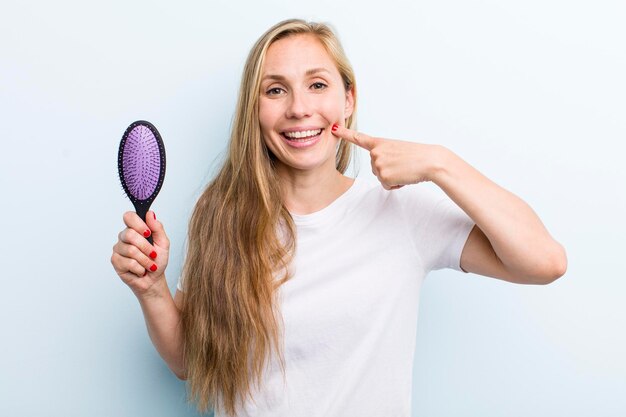 Pretty blonde young adult woman with a hair comb