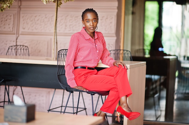 Pretty braids business african american lady bright bossy person friendly wear office red shirt and trousers, sitting on chair.
