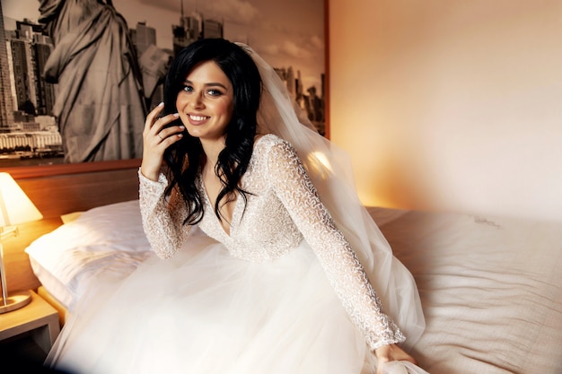 Photo pretty bride in her wedding dress posing indoors