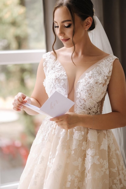 Красивая невеста держит в руках клятву и читает свадебное утро