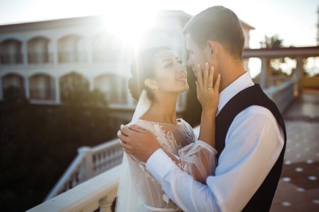 Pretty bride and stylish groom together on the bridge against the background of the boat Wedding