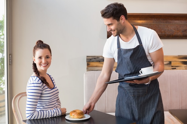 Pretty brunette being served a bagel