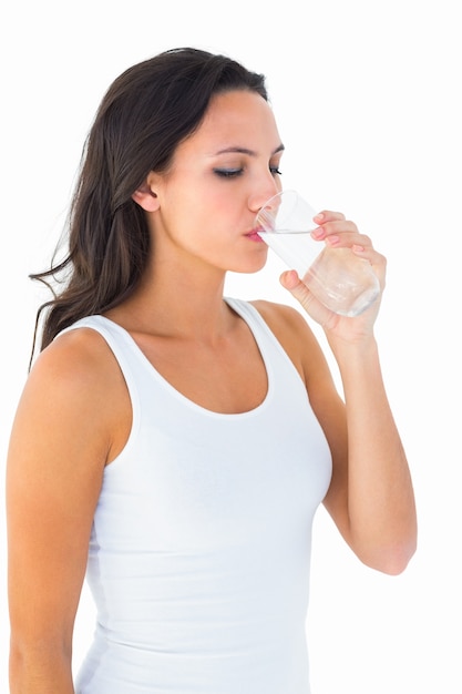 Pretty brunette drinking glass of water