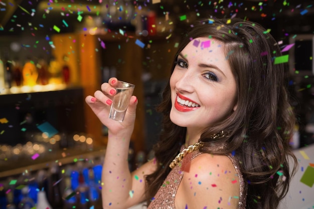 Pretty brunette drinking a shot against flying colours