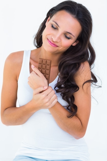 Pretty brunette eating bar of chocolate