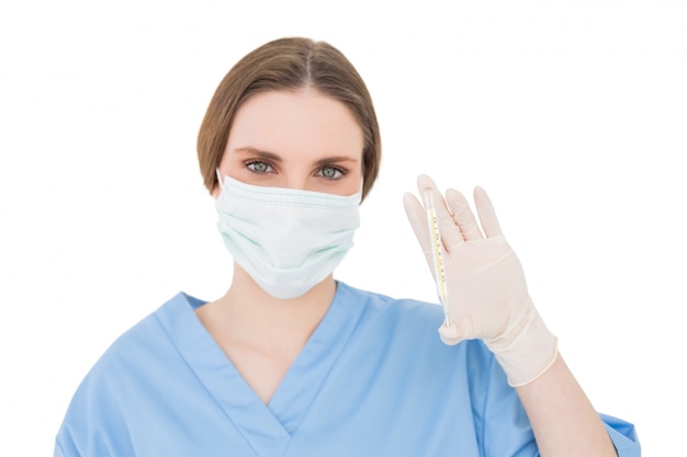 Pretty brunette female doctor holding a thermometer