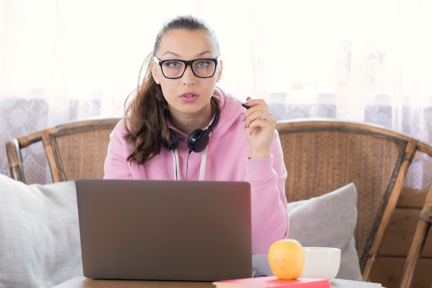 Pretty brunette girl works remotely with laptop computer