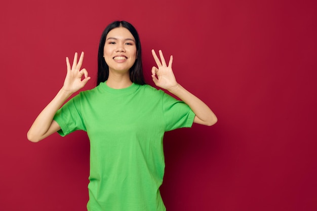 彼の手でかなりブルネットの緑のTシャツのジェスチャー赤い背景は変更されていません