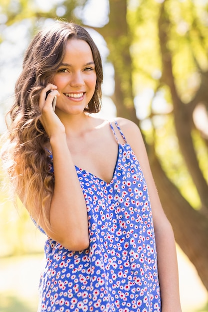 Pretty brunette having phone call in the park