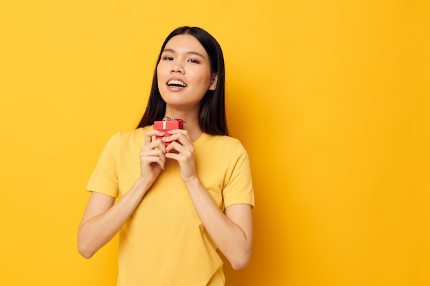 Pretty brunette holding a gift box in his hands posing lifestyle unaltered