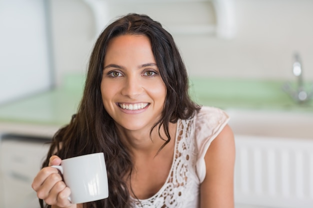 Pretty brunette holding a mug 