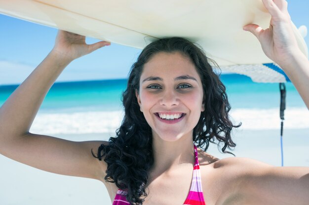 Pretty brunette holding surf board