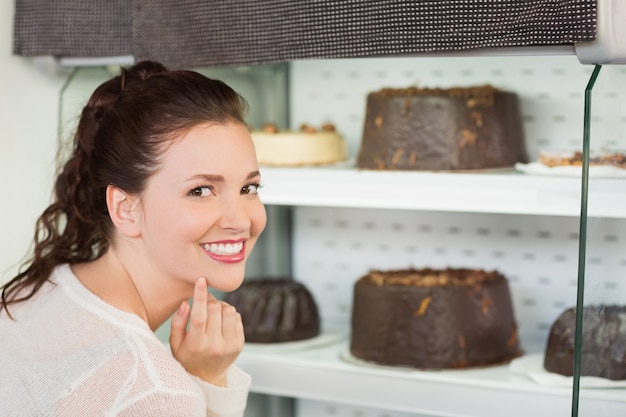 Pretty brunette looking at cake