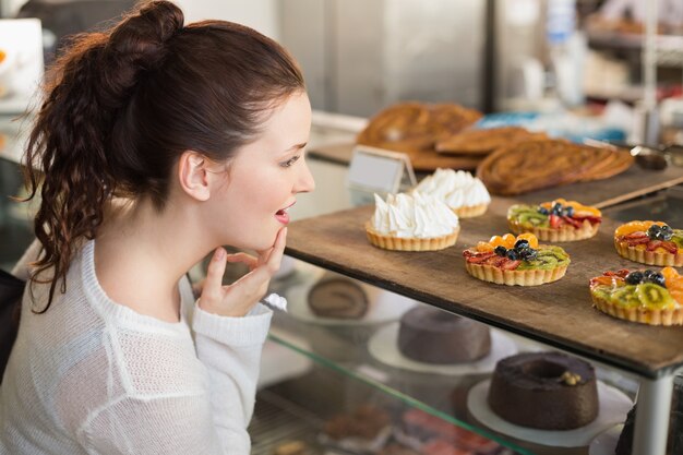 Pretty brunette looking at tarts