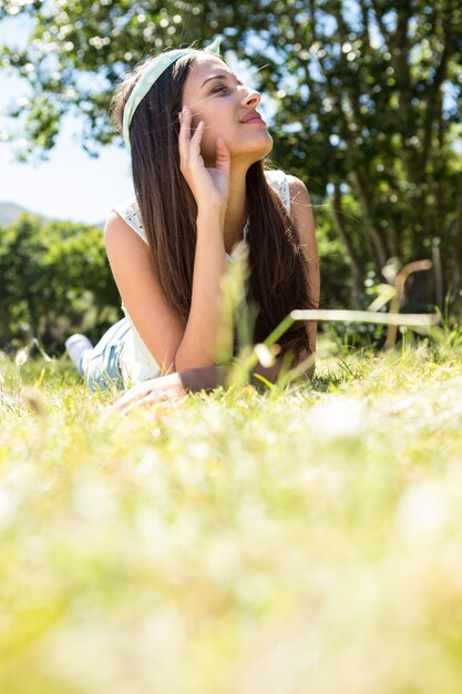 Pretty brunette lying on the grass on a summers day