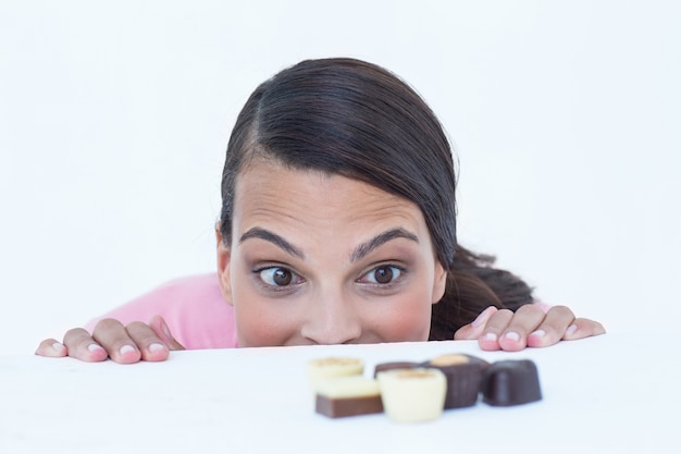 Pretty brunette peeking at chocolate